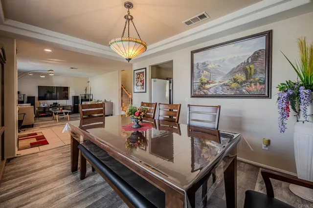 a view of a dining room and livingroom with furniture wooden floor a chandelier