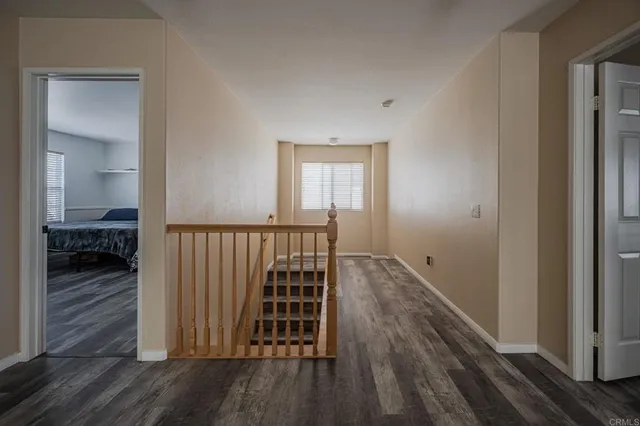 a view of a hallway with wooden floor and a bedroom