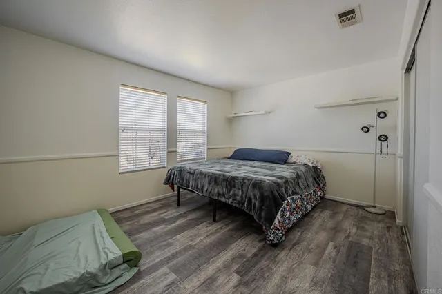a bedroom with a bed wooden floor and window