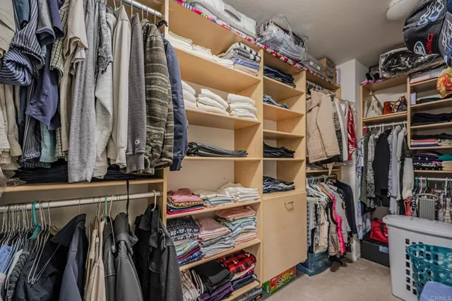 walk in closet with clothes