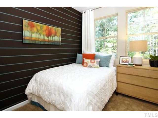 717 Wickham Ridge Road Apex, NC 27539 - Photo 12 of 25 a bed sitting in a bedroom next to a window
