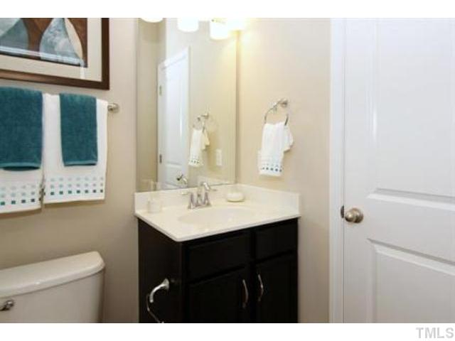 717 Wickham Ridge Road Apex, NC 27539 - Photo 13 of 25 a bathroom with a sink a mirror and a toilet