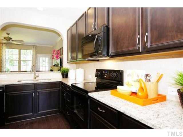 717 Wickham Ridge Road Apex, NC 27539 - Photo 6 of 25 a kitchen with a sink a stove and cabinets