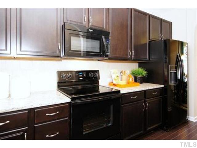 717 Wickham Ridge Road Apex, NC 27539 - Photo 7 of 25 a kitchen with a sink a microwave and refrigerator