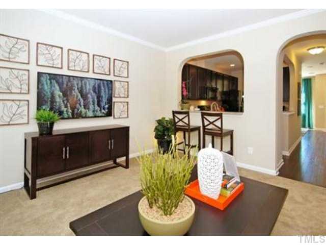 717 Wickham Ridge Road Apex, NC 27539 - Photo 10 of 25 a living room with furniture a flat screen tv and a fireplace