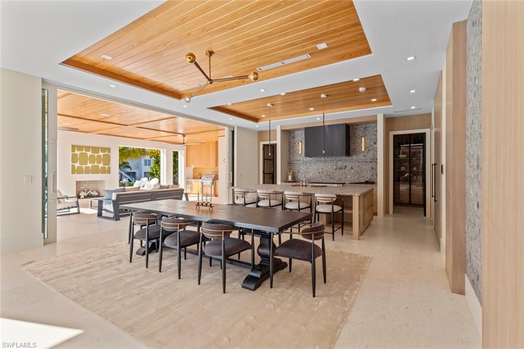 508 16th Avenue South Naples, FL 34102 - Photo 11 of 50 Dining room with a tray ceiling, wooden ceiling, a fireplace, and recessed lighting