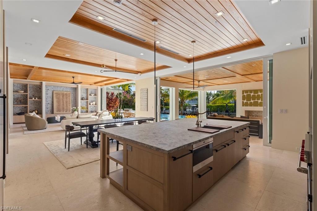 508 16th Avenue South Naples, FL 34102 - Photo 50 of 50 Kitchen featuring wooden ceiling, a raised ceiling, open floor plan, a kitchen island with sink, and modern cabinets