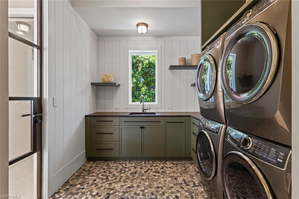 508 16th Avenue South Naples, FL 34102 - Photo 18 of 50 Laundry room featuring wood walls, dark flooring, cabinet space, and washer and clothes dryer