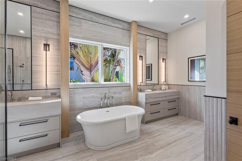 508 16th Avenue South Naples, FL 34102 - Photo 22 of 50 Full bath featuring vanity, healthy amount of natural light, a freestanding tub, recessed lighting, and tile walls