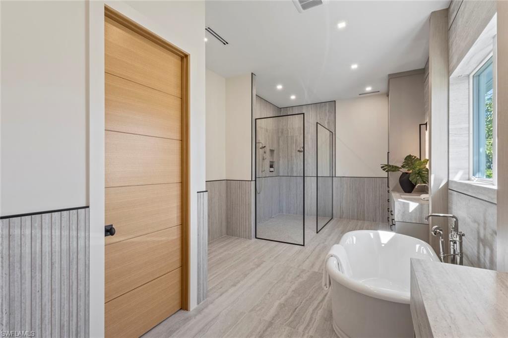 508 16th Avenue South Naples, FL 34102 - Photo 23 of 50 Full bath featuring wainscoting, a shower stall, recessed lighting, a freestanding bath, and vanity