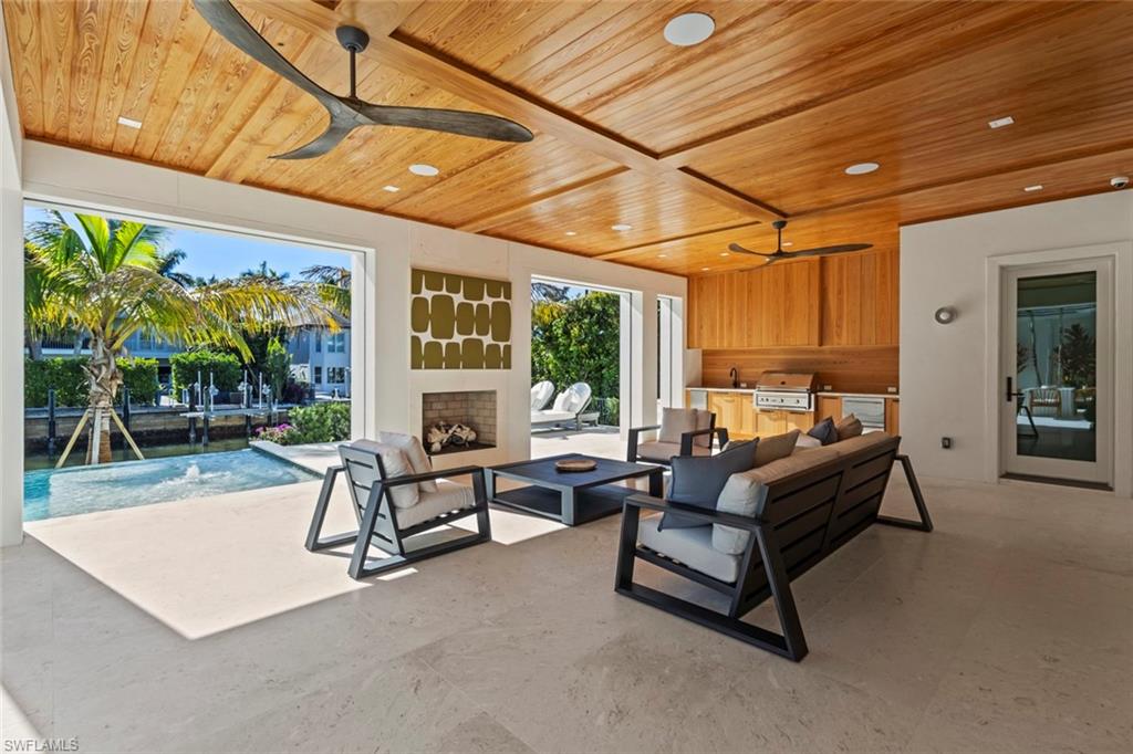 508 16th Avenue South Naples, FL 34102 - Photo 40 of 50 Living room with ceiling fan, wood ceiling, a fireplace, and recessed lighting