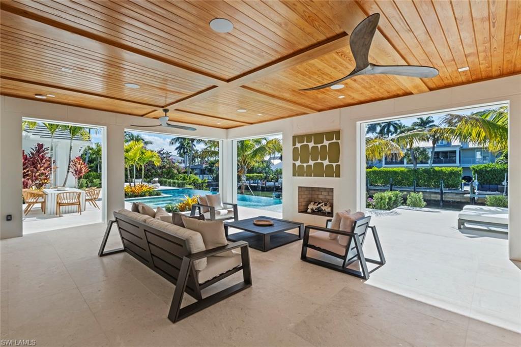 508 16th Avenue South Naples, FL 34102 - Photo 43 of 50 View of patio with a ceiling fan, an outdoor living space with a fireplace, and an outdoor pool