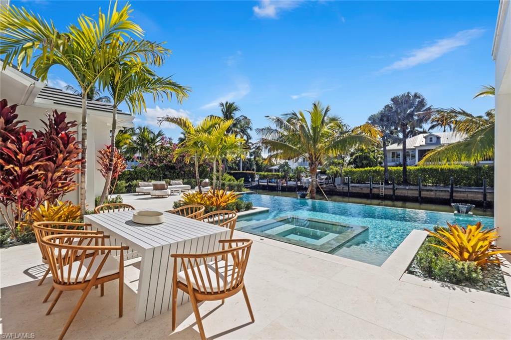 508 16th Avenue South Naples, FL 34102 - Photo 47 of 50 View of swimming pool featuring a patio, a pool with connected hot tub, and outdoor dining area