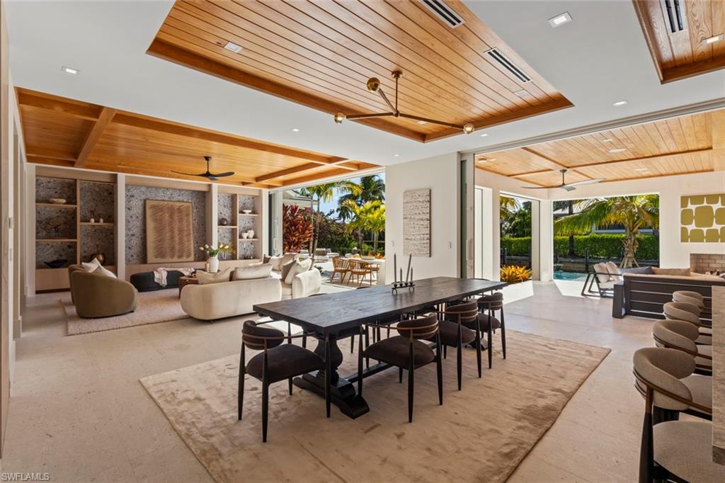 508 16th Avenue South Naples, FL 34102 - Photo 8 of 50 Dining area featuring wood ceiling, a tray ceiling, a sunroom, a ceiling fan, and floor to ceiling windows
