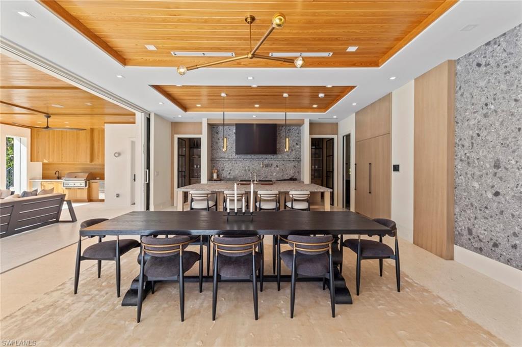 508 16th Avenue South Naples, FL 34102 - Photo 10 of 50 Dining space featuring wood ceiling, a raised ceiling, and an accent wall