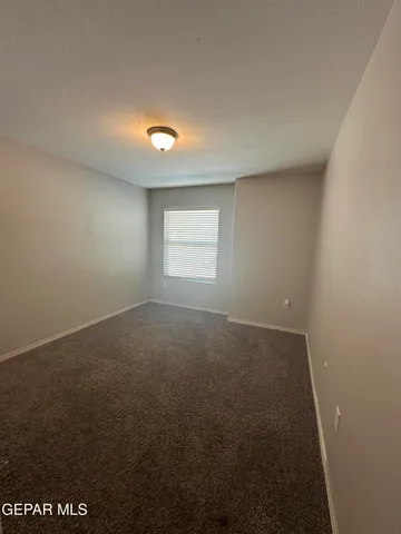 a view of a hallway with wooden floor and a living room