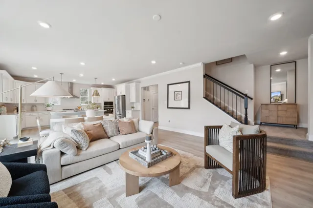 a living room with furniture kitchen view and a wooden floor