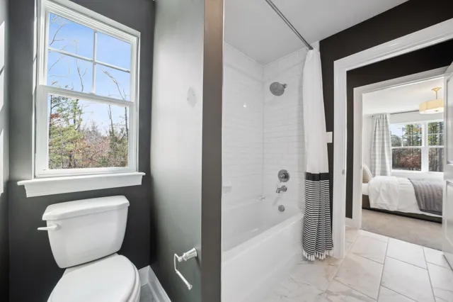 a bathroom with a toilet tub and shower