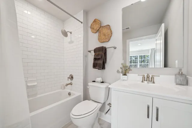 a bathroom with a granite countertop toilet sink and mirror