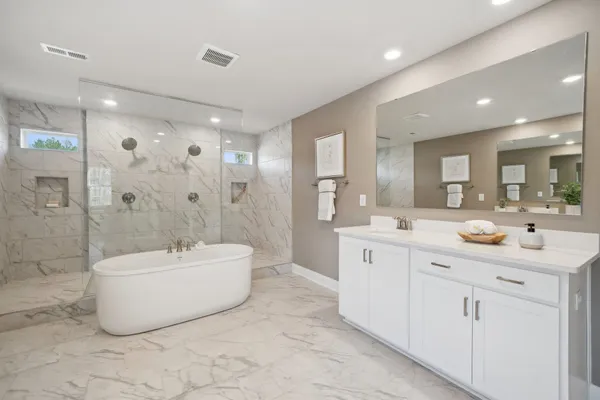 a spacious bathroom with a double vanity sink mirror bathtub and shower