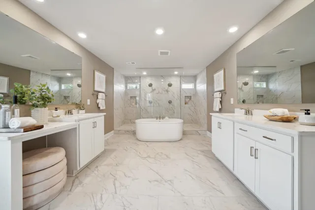 a large bathroom with a double vanity sink a large mirror and a bathtub