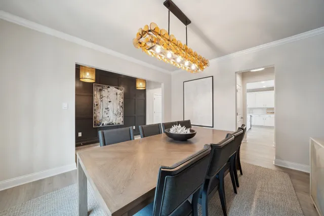 a dining room with kitchen island furniture a large window and a kitchen view