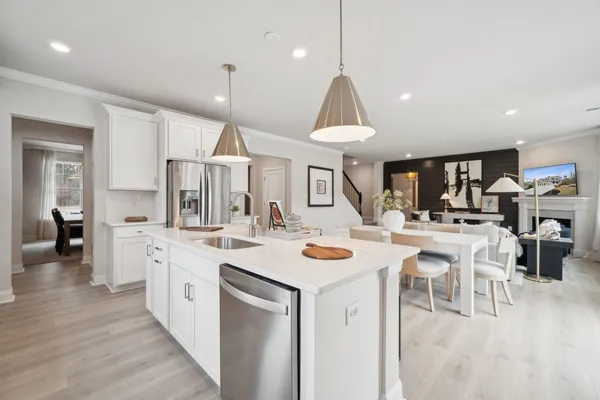 a open kitchen view with stainless steel appliances kitchen island a stove a chandelier a dining table and chairs