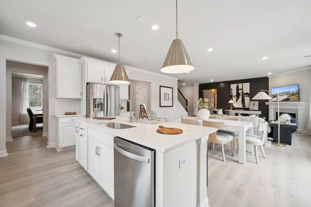 a open kitchen view with stainless steel appliances kitchen island a stove a chandelier a dining table and chairs