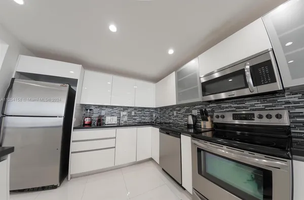 a kitchen with granite countertop a sink and a stove top oven