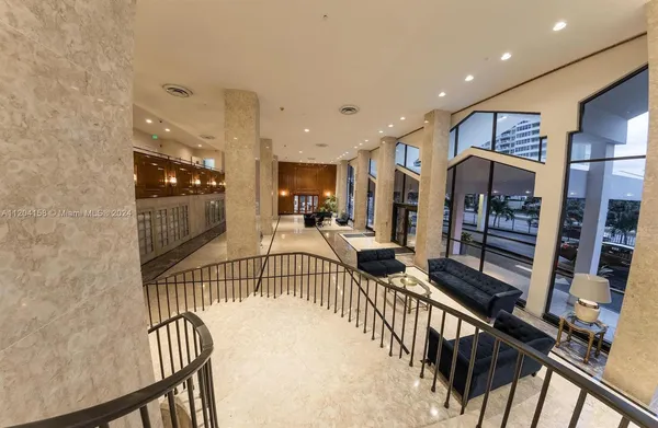 a living room with stainless steel appliances furniture a refrigerator and kitchen view
