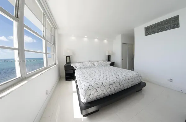 a bed sitting in a spacious bedroom next to a window