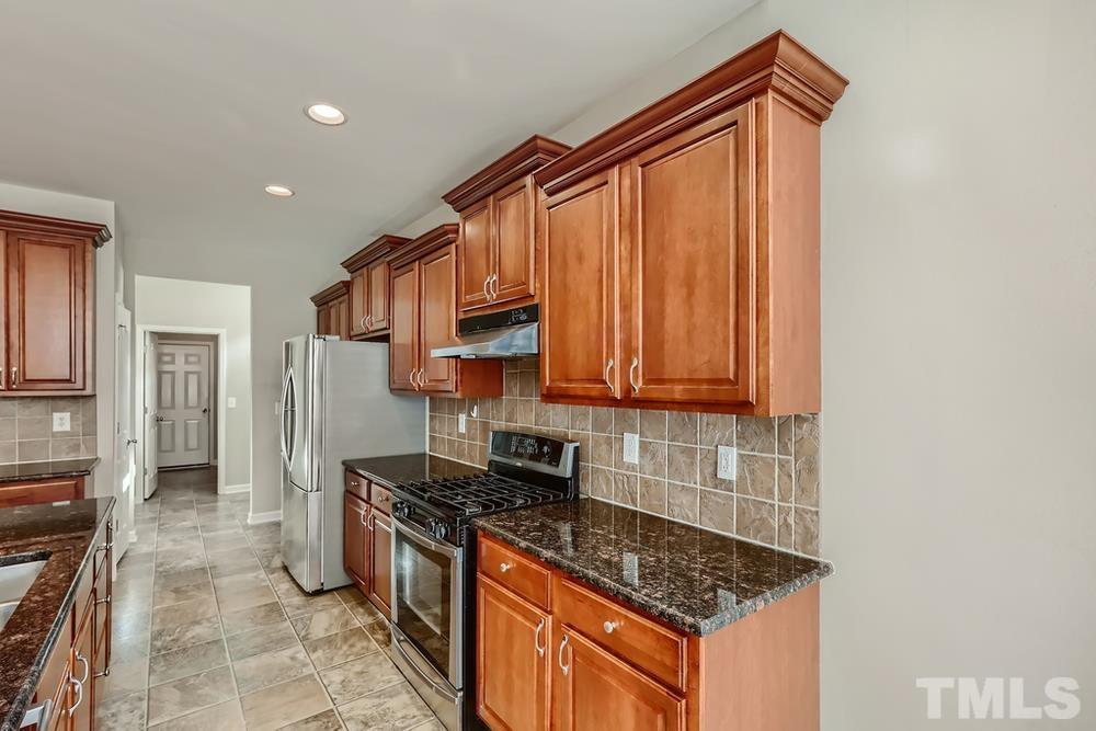 7809 Berry Crest Avenue Raleigh, NC 27617 - Photo 12 of 27 a kitchen with stainless steel appliances granite countertop a stove a sink and a microwave