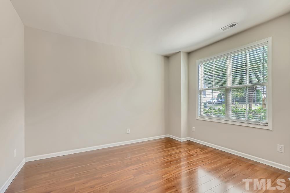 7809 Berry Crest Avenue Raleigh, NC 27617 - Photo 14 of 27 an empty room with wooden floor and windows