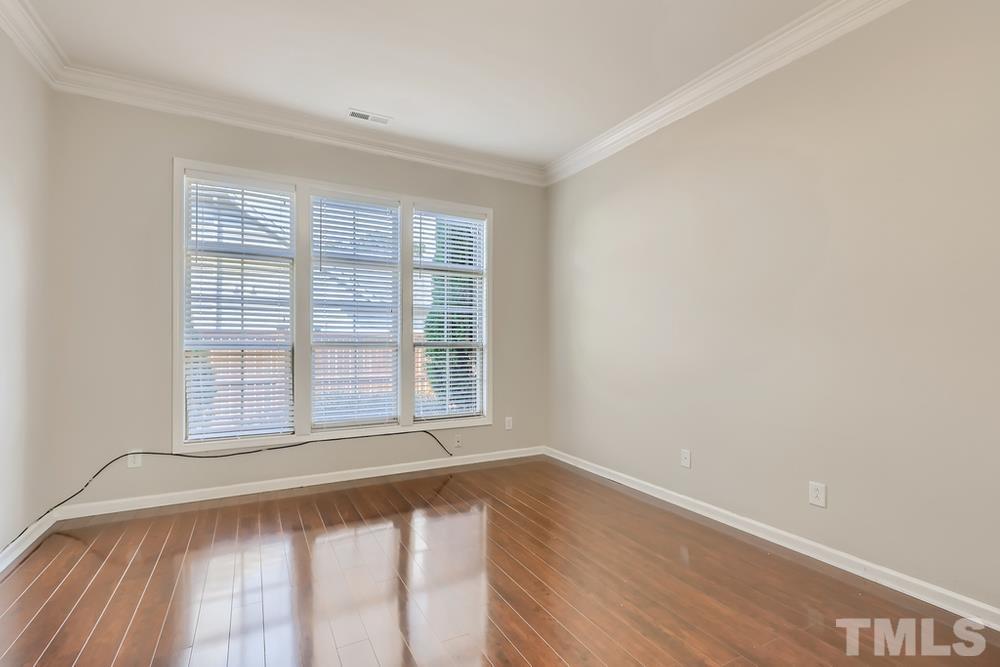 7809 Berry Crest Avenue Raleigh, NC 27617 - Photo 15 of 27 a view of an empty room with wooden floor and a window