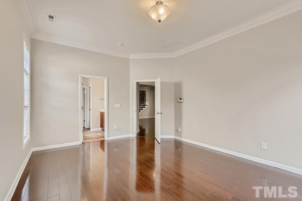 7809 Berry Crest Avenue Raleigh, NC 27617 - Photo 16 of 27 a view of an empty room with wooden floor and a window