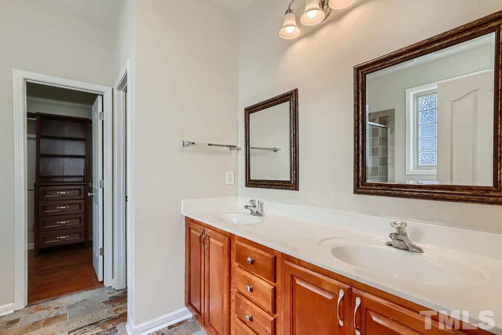 7809 Berry Crest Avenue Raleigh, NC 27617 - Photo 17 of 27 a bathroom with double sink and a mirror