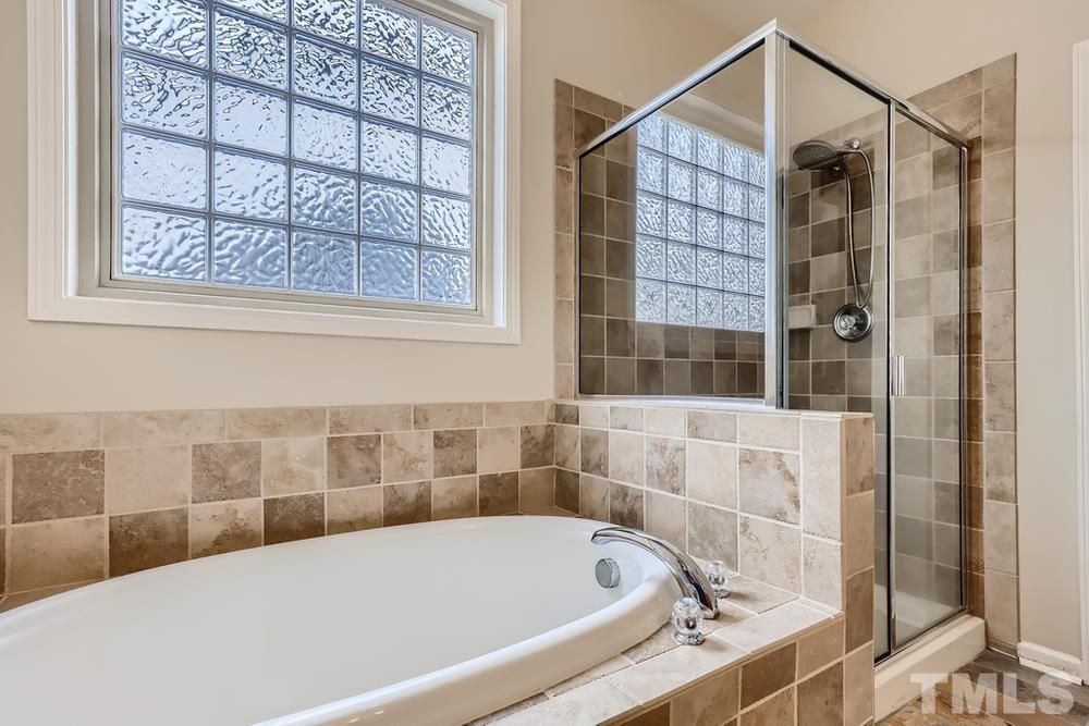 7809 Berry Crest Avenue Raleigh, NC 27617 - Photo 18 of 27 a bathroom with a bathtub and shower