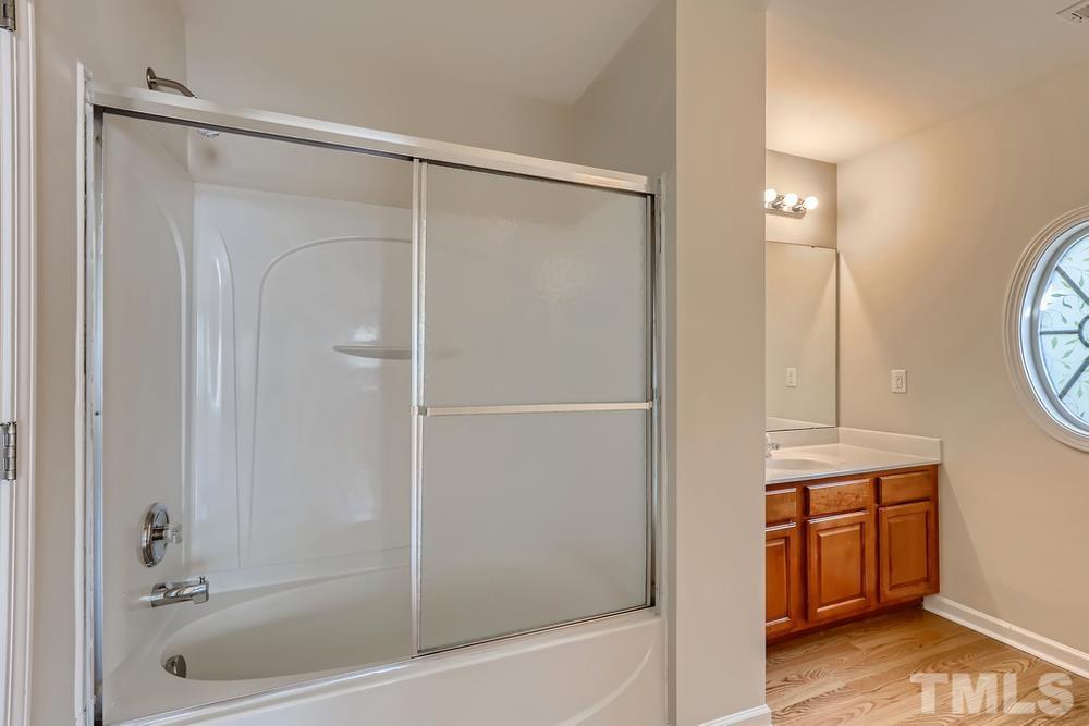7809 Berry Crest Avenue Raleigh, NC 27617 - Photo 20 of 27 a bathroom with a shower a mirror and a sink