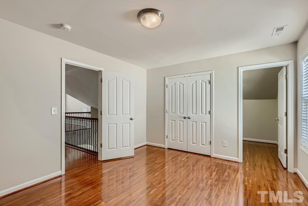 7809 Berry Crest Avenue Raleigh, NC 27617 - Photo 21 of 27 an empty room with wooden floor and closet