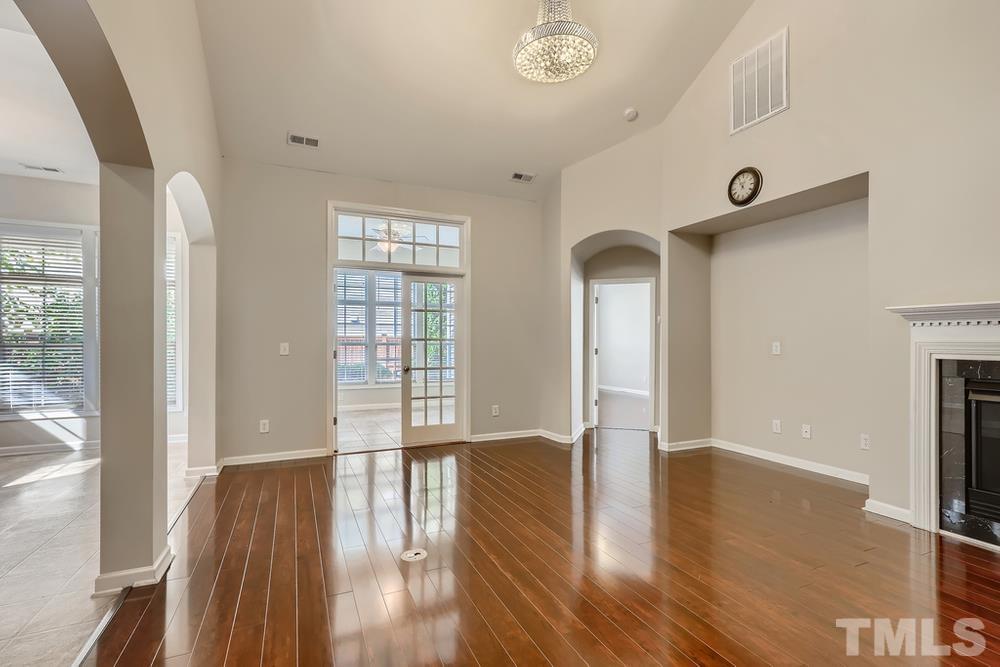 7809 Berry Crest Avenue Raleigh, NC 27617 - Photo 7 of 27 a view of an empty room with wooden floor and a window