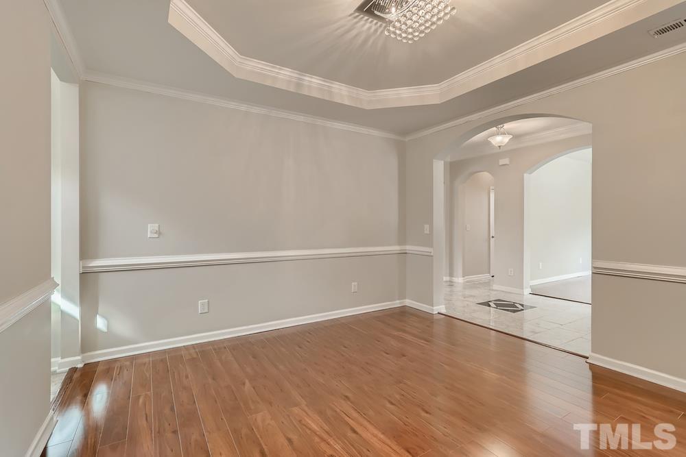 7809 Berry Crest Avenue Raleigh, NC 27617 - Photo 9 of 27 a view of an empty room with wooden floor