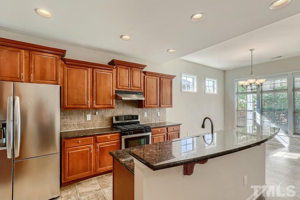 7809 Berry Crest Avenue Raleigh, NC 27617 - Photo 10 of 27 a kitchen with stainless steel appliances granite countertop a refrigerator a stove a sink dishwasher a microwave oven with cabinets and wooden floor