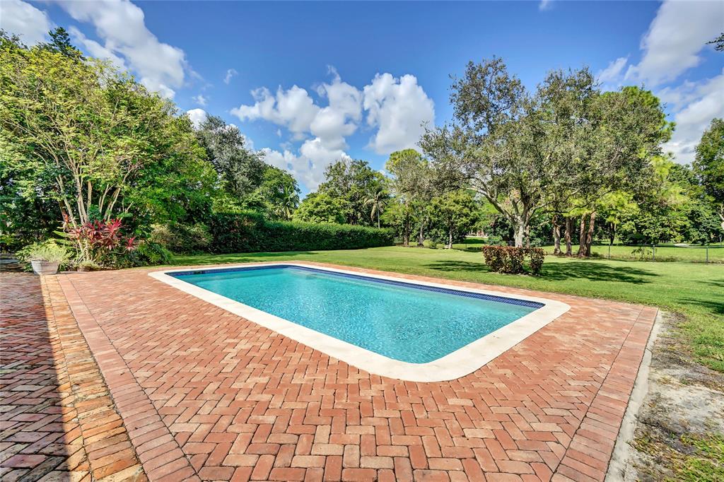 Southwest Ranches Southwest Ranches, FL 33331 - Photo 43 of 50 a view of a swimming pool and trees in the background