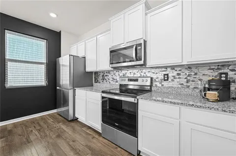 a kitchen with stainless steel appliances granite countertop a stove a microwave and a refrigerator