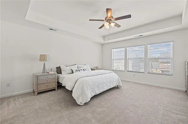 a spacious bedroom with a bed couch and window