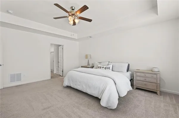 a spacious bedroom with a bed and a ceiling fan