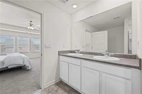 a en suite bathroom with double vanity and a mirror