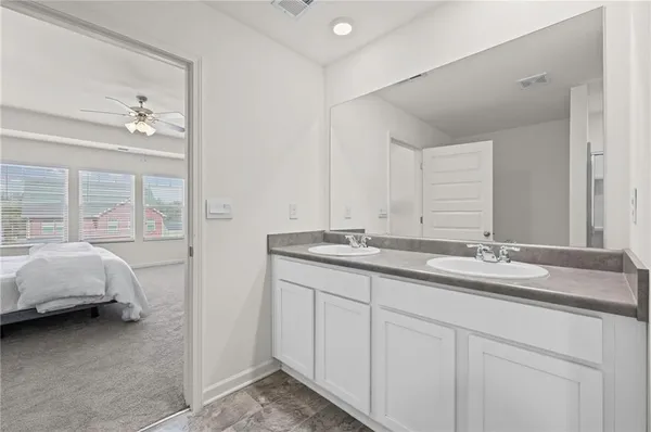 a en suite bathroom with double vanity and a mirror