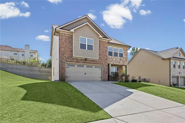 a front view of a house with a yard and garage