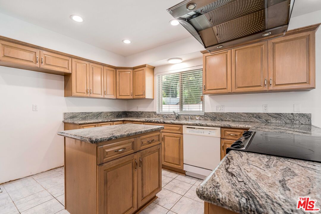 1181 Somera Road Los Angeles, CA 90077 - Photo 14 of 40 a kitchen with stainless steel appliances granite countertop a stove a sink and a microwave